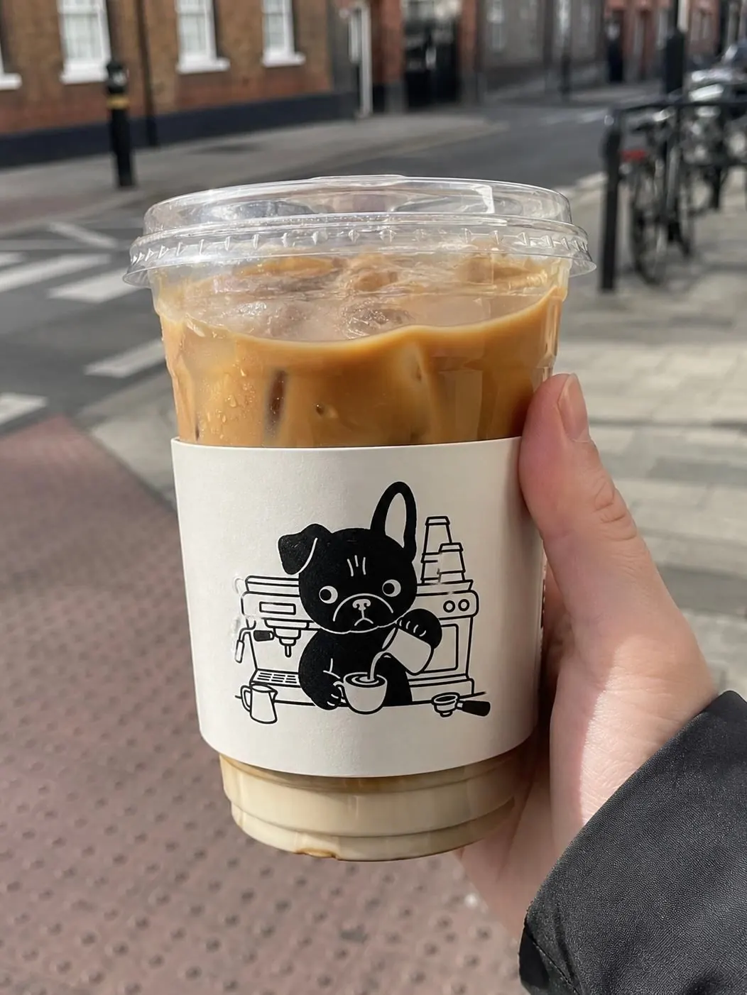 Iced latte in a Black Dawg cup with the mascot printed on the sleeve