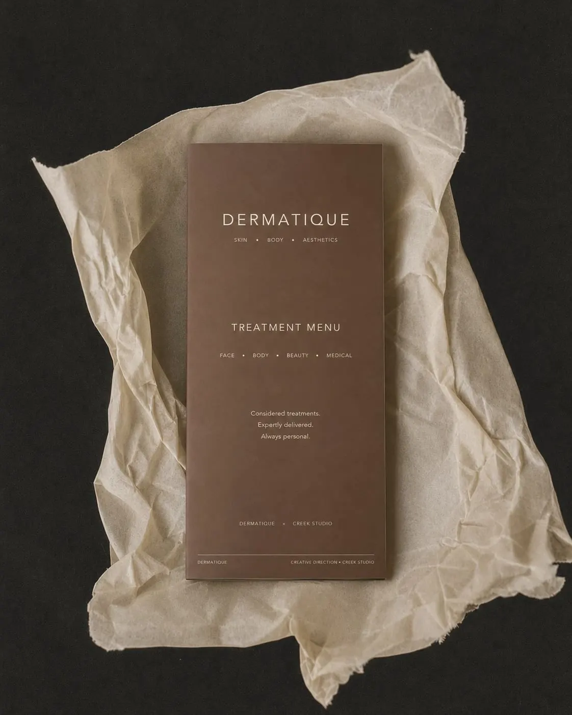 Dermatique treatment menu resting on crumpled tissue paper