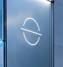 The Face Space monogram etched on blue glass: an open oval crossed by a line that runs past it on both sides