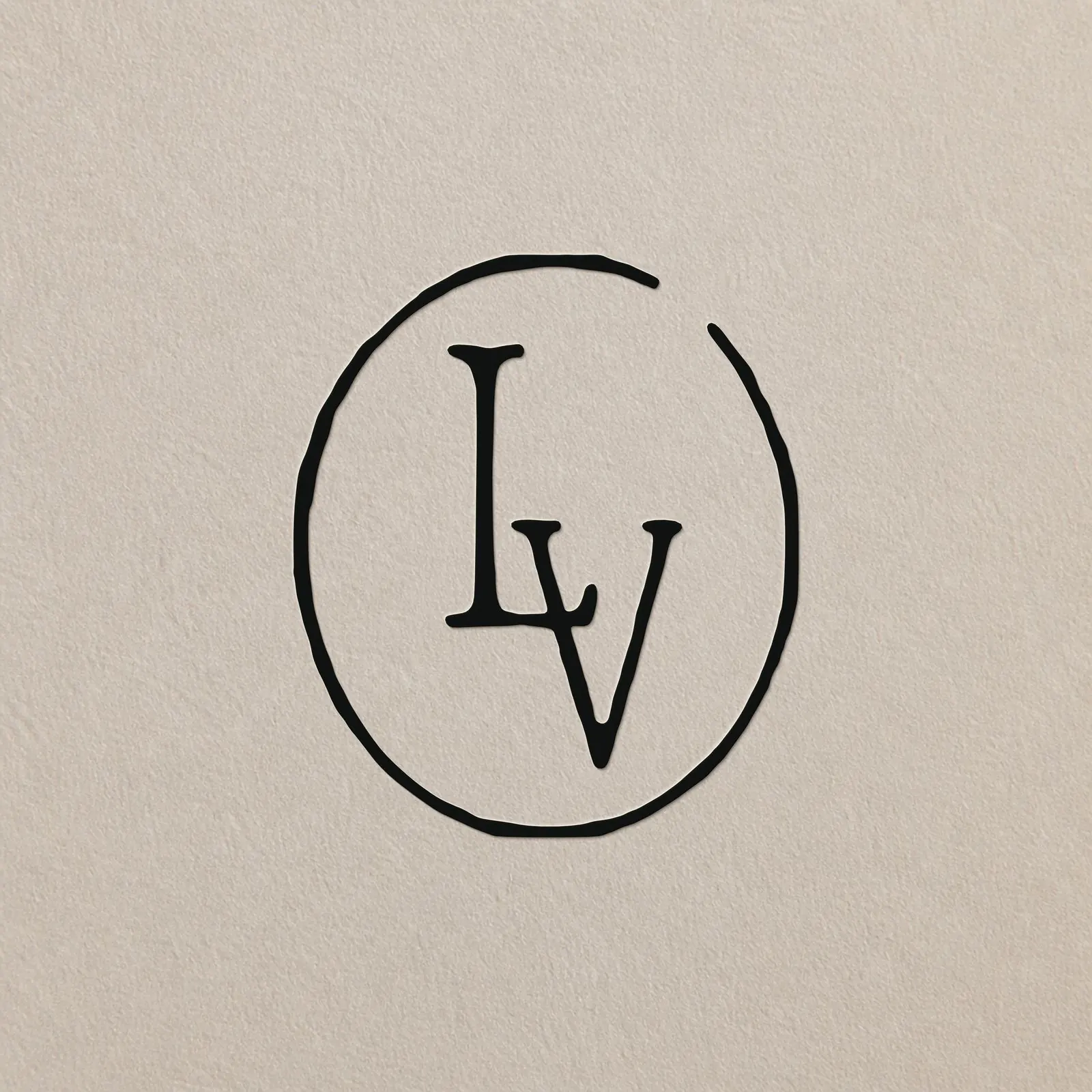 The La Velada LV monogram in a hand-drawn circle on textured paper